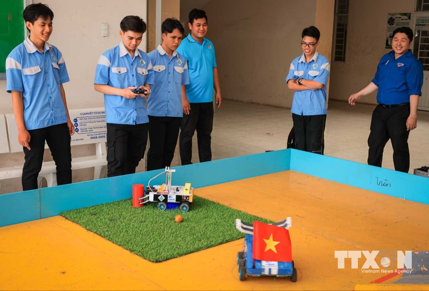 Sinh viên tích cực luyện tập, hiệu chỉnh hoàn thiện robot trên thực tế mô hình thi đấu robocon, với sự hỗ trợ chuyên môn của giảng viên khoa Điện tử. (Ảnh: Hoàng Hiếu/TTXVN)